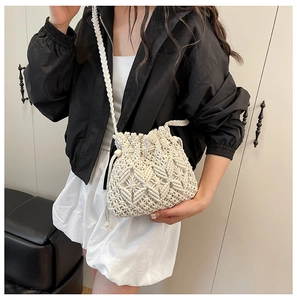 Detailed view of handmade cream woven bucket bag with macrame geometric pattern and strap
