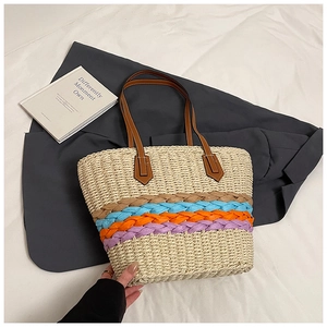Detail of colorful woven tote bag with striped pattern and leather handles on white background