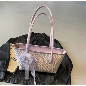 Detail of purple geometric floral bucket bag with lace bow on a leather jacket