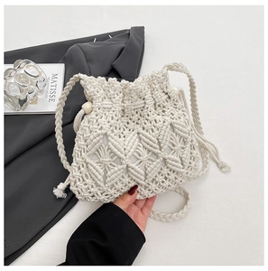 Detail of hand-woven straw bucket bag with drawstring closure and wooden bead accents