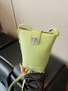 Fashionable light green bucket bag in pebble leather with silver twist lock and crossbody strap