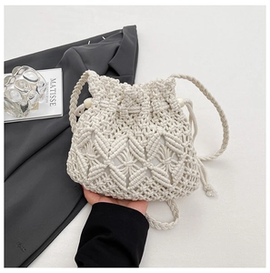 Detailed shot of beige handmade woven bucket bag with intricate crochet pattern and drawstring