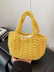 Handmade yellow woven bucket bag with V-shaped texture and cream drawstring inner bag