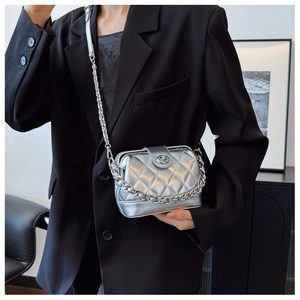 Detail of silver metallic quilted crossbody bag with luxury chain strap and twist lock