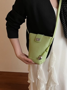 Lime green pebbled leather bucket bag with silver heart charm and metal twist lock