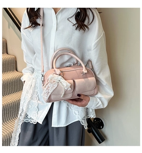 Pink bowling bag with lace bow accessory worn by model over a white shirt