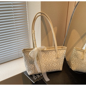 Detailed view of cream jacquard tote bag with elegant white lace ribbon decoration