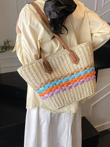 Women's woven straw bucket bag featuring colorful striped bands and brown shoulder straps