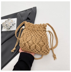 Detail of hand-woven straw bucket bag featuring geometric patterns and drawstring closure
