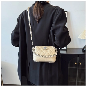 Quilted beige crossbody bag featuring silver hardware and a chain strap on model