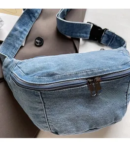 Detail of light blue denim chest bag with dual zippers and adjustable buckle strap