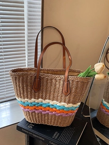 Handwoven straw bucket bag with colorful stripes and brown leather handles for summer