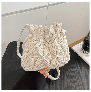 Detail of macrame straw bucket bag with woven hollow pattern and natural wooden beads