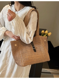 Minimalist woven straw tote bag with black leather strap and tulip decoration