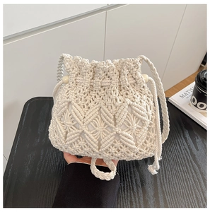 Detailed close-up of diamond-pattern woven texture on a cream bohemian bucket bag