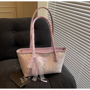 Detail of purple tote bag with floral embroidery and lace bow on a soft velvet sofa
