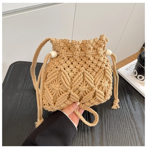 Detail of hand-woven beige bucket bag featuring floral crochet patterns and drawstring tassels
