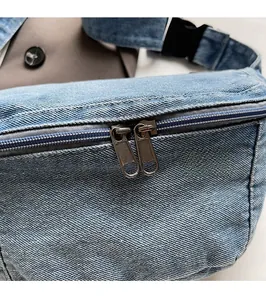 Detailed macro view of durable denim fabric and smooth double metal zippers on the bag