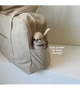 Macro view of side pocket on beige travel tote showing storage for a folding umbrella