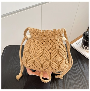 Detail view of woven drawstring bucket bag with macrame pattern and white wooden beads