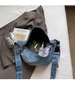 Internal view of blue denim crossbody bag showing spacious capacity and daily items