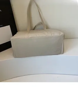 Detail of a beige lightweight nylon tote bag showing the wide bottom and durable texture
