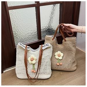 Dettaglio della borsa tote a rete intrecciata con fiore fatto a mano e manici in pelle