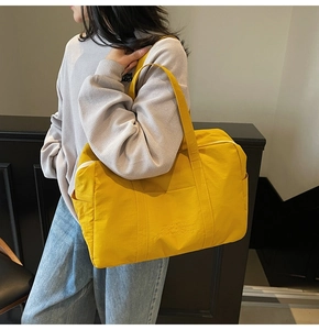 Close-up of ginger yellow canvas tote bag with dream engraving worn by a model