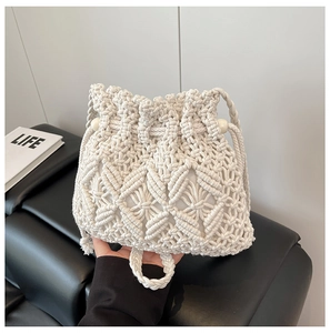 Detail of handmade macrame straw bucket bag with woven patterns and drawstring closure
