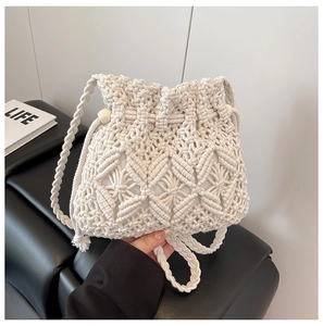 Detailed close-up of handmade woven straw bucket bag with diamond wheat pattern