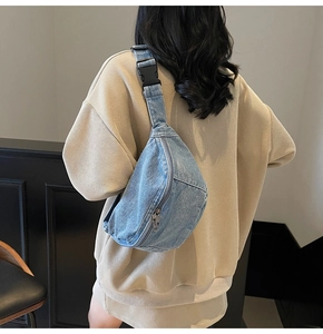 Detailed back view of a light blue denim crossbody chest bag with adjustable black strap