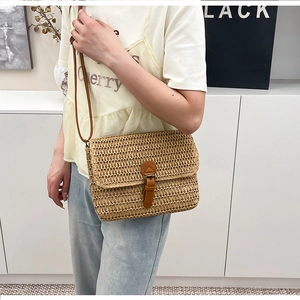 Détail du tissage en paille et de la bandoulière en cuir d'un sac de plage vintage