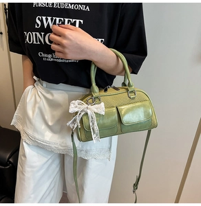 Detail of light green bowling bag featuring lace bow charms and pearl accents