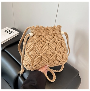 Close-up of a khaki woven bucket bag featuring intricate patterns and drawstring with beads