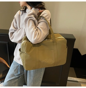 Olive green nylon tote bag with large capacity shown in a casual lifestyle setting