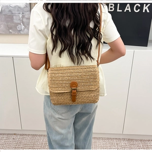 Vue détaillée du sac à bandoulière en paille avec lanière en cuir marron sur modèle