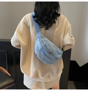 Rear view of model wearing a light blue denim crossbody bag with adjustable wide strap