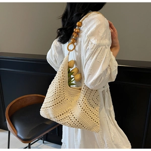 Detailaufnahme der beigen Häkeltasche mit Holzperlen-Schultergurt und Lochstrickmuster