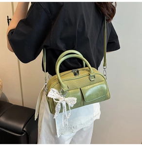 Detail of green woven bowling bag featuring leather pockets and lace pearl bow charm