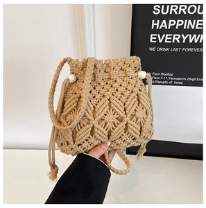 Detail of woven straw bucket bag showing textured pattern and drawstring closure with beads