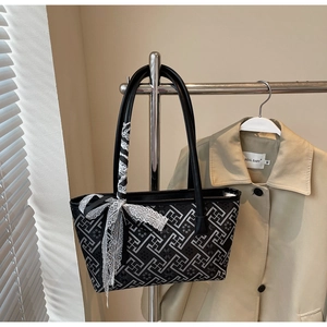 Detail of printed bucket bag with geometric patterns and lace scarf on a metal hanger