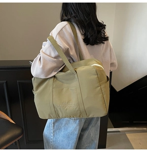 Olive green large canvas tote bag with side pocket shown from back on a model