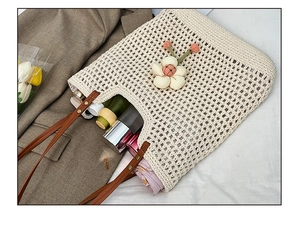 Dettaglio della borsa tote intrecciata con interno spazioso, cosmetici e decoro floreale