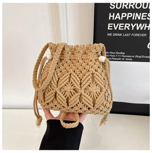 Detailed close-up of woven beige straw bucket bag with drawstring and bead handles