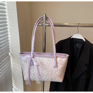 Detail of lavender floral jacquard tote bag featuring a large white lace bow and silk ribbon