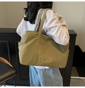 Detailed close-up of olive green nylon tote bag with VIGOUR VIVID quote print