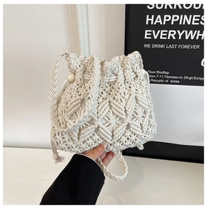 Detail of hand-woven cream bucket bag featuring hollow diamond patterns and drawstring