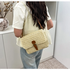 Mannequin portant un sac bandoulière carré en paille avec boucle en cuir brun