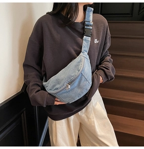 Detail shot of light blue denim crossbody chest bag with adjustable strap and plastic buckle