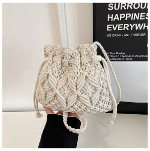 Close-up of cream handmade woven bucket bag with intricate crochet diamond patterns